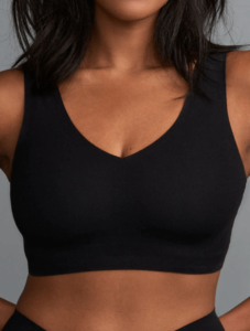 Chest of a woman wearing a black cotton bralette
