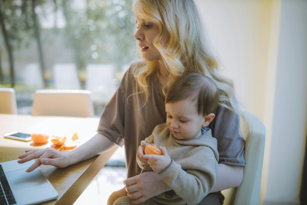 Busy Mom with kid in lap possibly searching for bralettes online