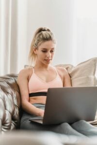 woman in bed wearing a bra doing work from home